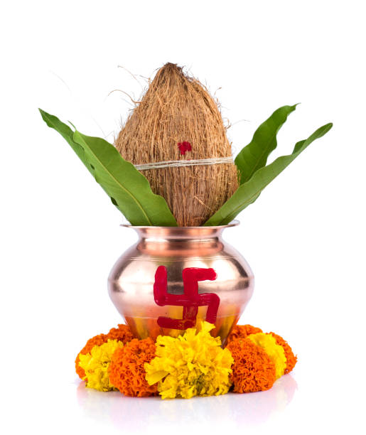 istock Copper Kalash with coconut and mango leaf with floral decoration on a white background. Essential in Hindu Puja. 1188094394