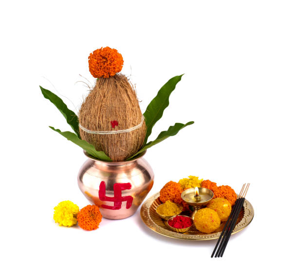 istock Copper Kalash with coconut and mango leaf and pooja thali with diya, kumkum and sweets with floral decoration on a white background. Essential in hindu puja. 1188094457