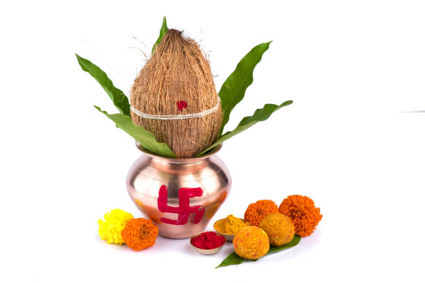 istock Copper Kalash with coconut, mango leaf, Haldi, kumkum and sweets with marigold flower decoration on a white background. Essential in Hindu puja. 1188094557