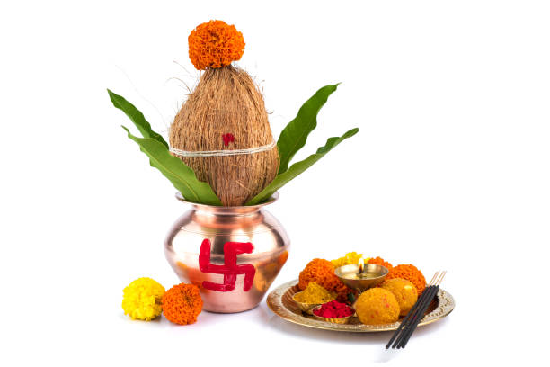 istock Copper Kalash with coconut and mango leaf and pooja thali with diya, kumkum and sweets with floral decoration on a white background. Essential in hindu puja. 1188094576
