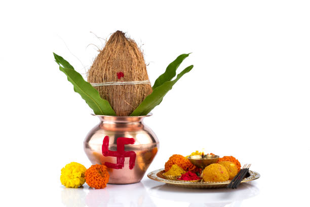 istock Copper Kalash with coconut and mango leaf and pooja thali with diya, kumkum and sweets with floral decoration on a white background. Essential in hindu puja. 1188098781