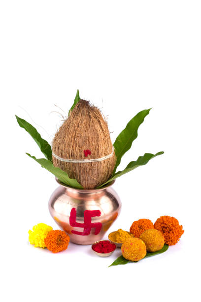 istock Copper Kalash with coconut, mango leaf, Haldi, kumkum and sweets with marigold flower decoration on a white background. Essential in Hindu puja. 1188099841