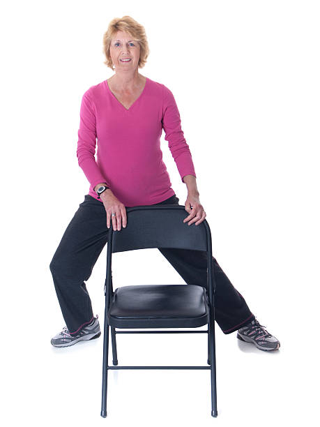 Senior woman stretch exercise with chair stock photo