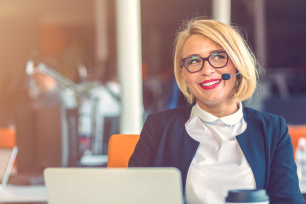 istock Customer service representative at work. Beautiful young woman in headset working at the computer 1188101071