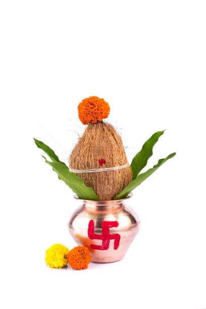 istock Copper Kalash with coconut and mango leaf with floral decoration on a white background. Essential in Hindu Puja. 1188101079