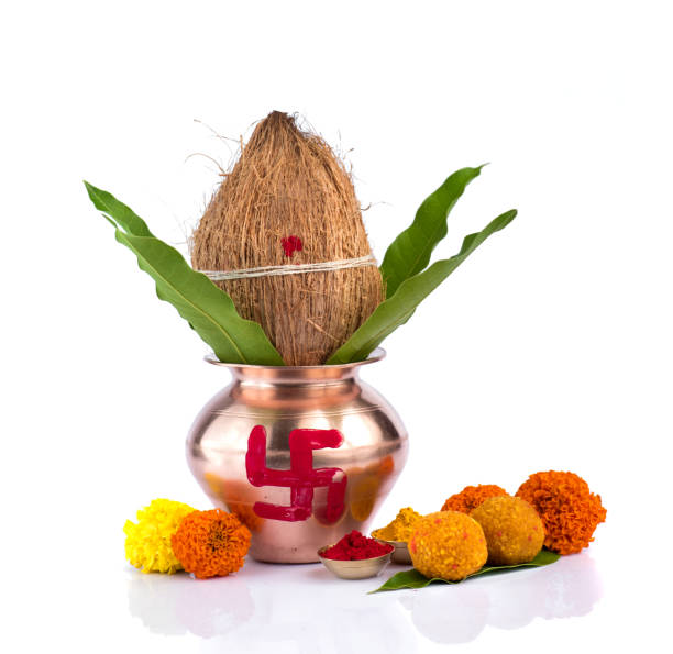 istock Copper Kalash with coconut, mango leaf, Haldi, kumkum and sweets with marigold flower decoration on a white background. Essential in Hindu puja. 1188101138