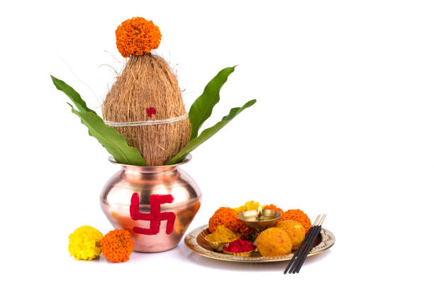 istock Copper Kalash with coconut and mango leaf and pooja thali with diya, kumkum and sweets with floral decoration on a white background. Essential in hindu puja. 1188101156