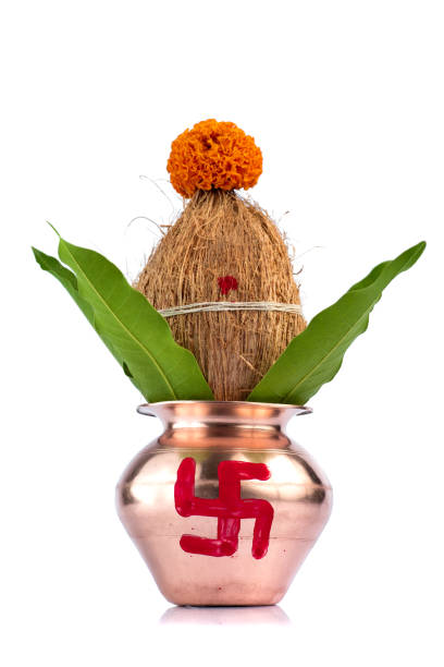 istock Copper Kalash with coconut and mango leaf with floral decoration on a white background. Essential in Hindu Puja. 1188101204