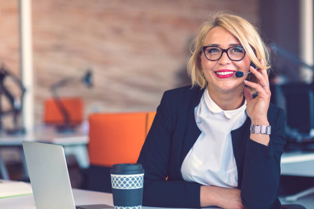 istock Customer service representative at work. Beautiful young woman in headset working at the computer 1188102743