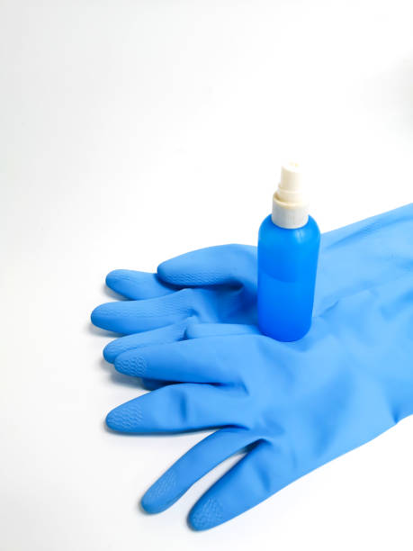 istock Blue rubber gloves with a cleaning solution bottle on a white background. House concept 1188106626