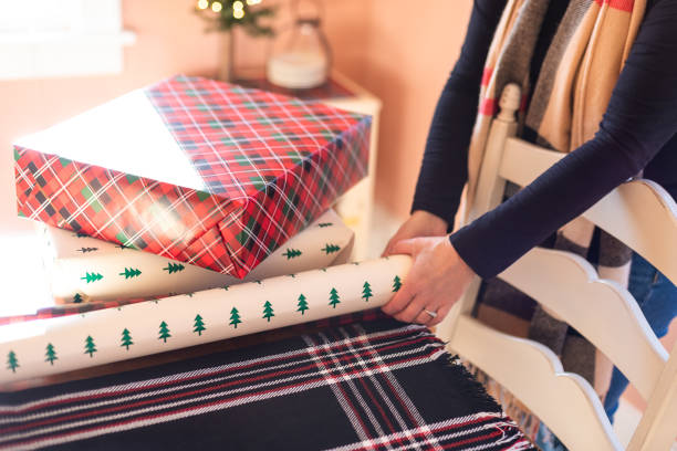 istock person wrapping Christmas presents 1188107421