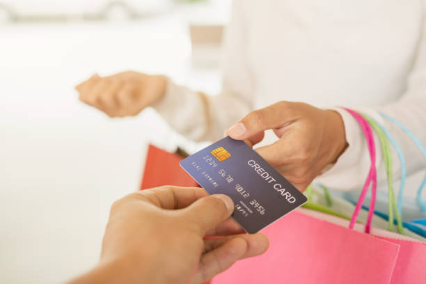 istock Young woman with shopping bag using credit card payment 1188108162