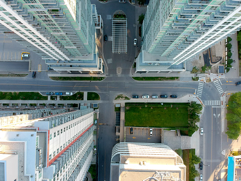 Aerial view of residential skyscrapers made of glass in the city from the top. Below is the road intersection. Housing development and infrastructure concept in modern American city.