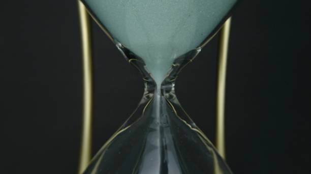istock Hourglass clock time concept. Old vintage gold metal frame green sand clock countdown on dark background. Close up. 1188108921