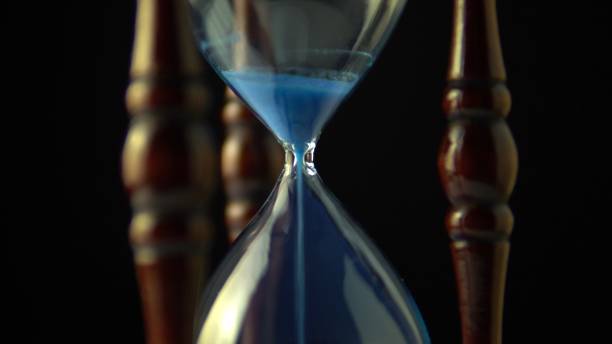 istock Hourglass clock time concept. Old vintage wood frame blue sand clock countdown on dark background. Close up. 1188108975