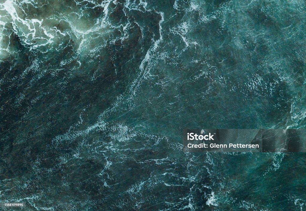 Abstract view of surfer in ocean. Top doen view of surfer in waves. Sea Stock Photo