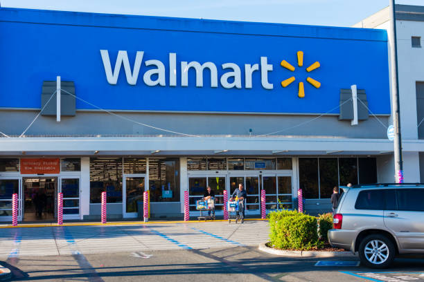 clients quittant le magasin walmart avec des paniers d'achat. les bornes anti-ram raiding sécuriser l'entrée d'un accident ou d'un vol - walmart photos et images de collection