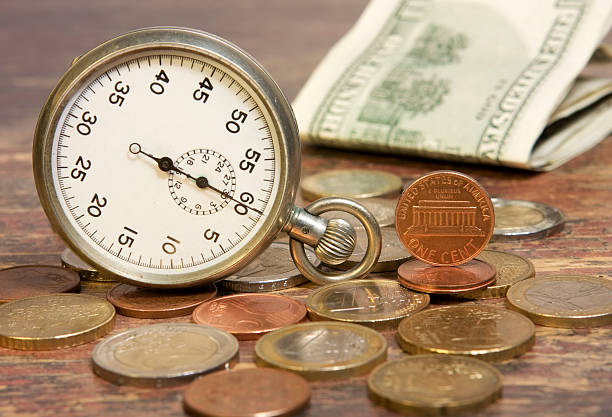 時間と費用 - finance photography us currency stopwatch ストックフォトと画像