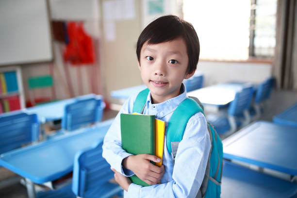 istock Young boy reading at his desk in a classroom 1188161258