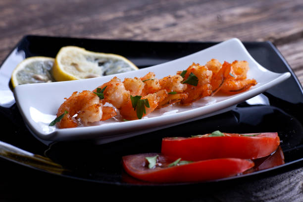 istock Fried prawns in a black plate on gray boards. 1188161532