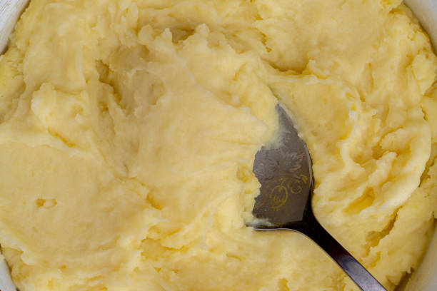 istock top view close up of mashed yellow potatoes texture with spoon in it 1188162305