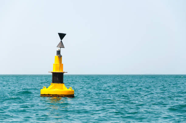 floating yellow buoy with a black strip on blue sea