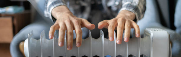 istock feeling cold, getting warm, hands touching the heater close up 1188164472