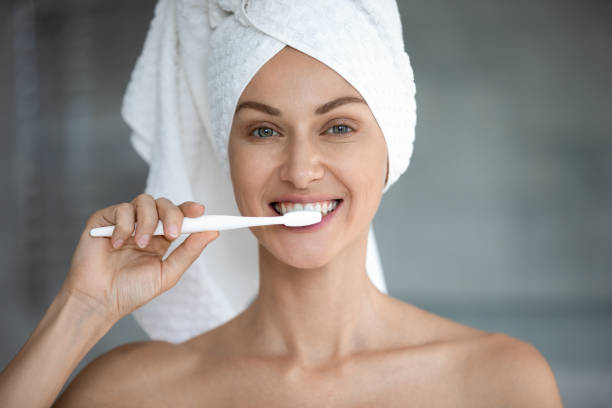 istock Happy young woman brushing healthy teeth looking at camera 1188167197