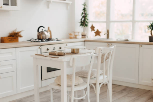 istock Modern new bright kitchen interior with white furniture and a dining table. 1188170650