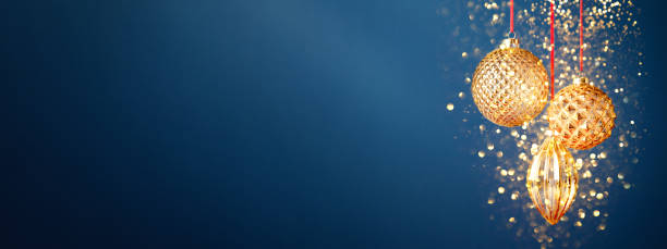 Three golden Christmas baubles on the dark blue background.
