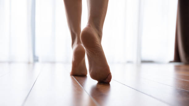 weibliche füße gehen auf warmem fußboden aus nächster nähe - fuß anatomiebegriff fotos stock-fotos und bilder