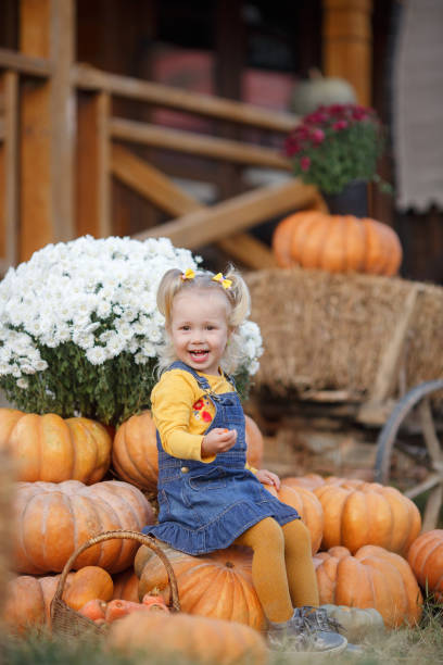 istock Cute little girl having fun with huge pumpkins on a pumpkin patch. 1188172193