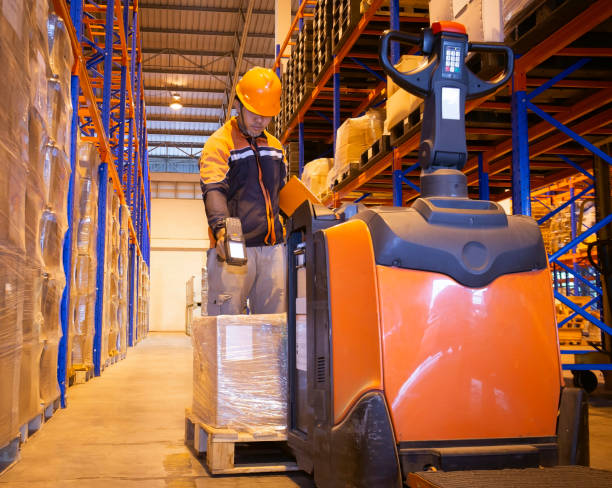 istock warehouse worker scanning bar code scanner with goods pallet and electric forklift pallet jack 1188174850