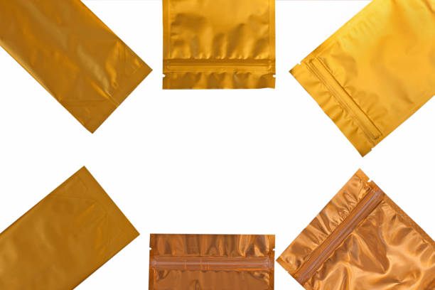 Golden metalized side gusset pouch bags isolated on white background. Empty blank bronze foil packaging template mockup. Trendy aluminium metallic coffee and tea package with zipper, top view,flatlay.
