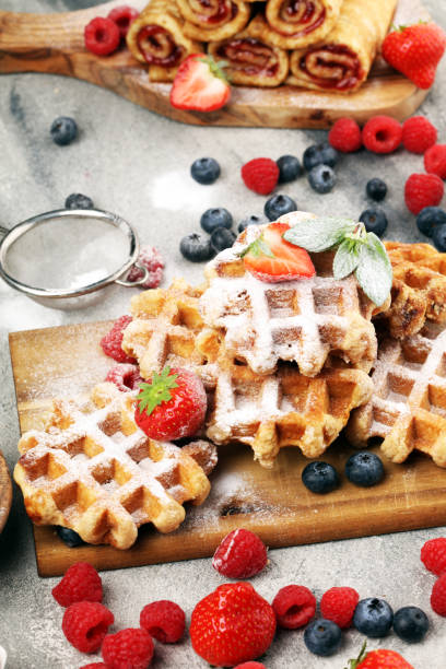 istock Traditional belgian waffles with fresh blueberries, sugar and raspberries on rustic table 1188175952