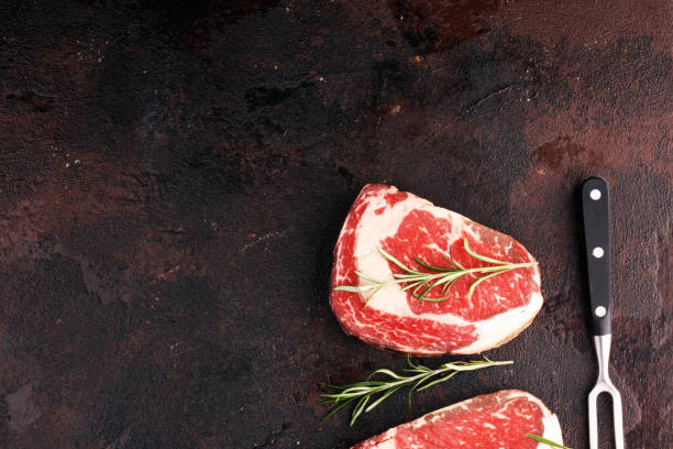 istock Raw fresh meat Ribeye Steak, seasoning and meat fork on rustic background 1188176819