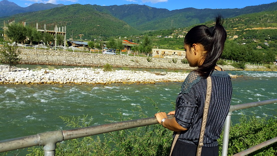 Peace of mind - tourist looking at river in Paro, Bhutan.