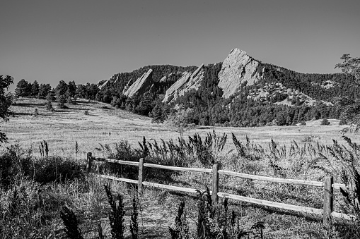 beautiful image of the Flatirons dark granite mountains from below with green and yellow lawns, in Chautauqua Park in Boulder Colorado