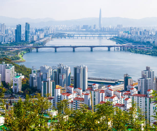 Seoul highrise housing skyscraper cityscape along Han River Korea Aerial photograph over the high-rise housing, skyscrapers and iconic spire of the Lotte World Tower along the Han River in central Seoul, South Korea’s vibrant capital city. kangnamgu stock pictures, royalty-free photos & images