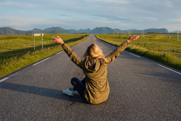 Woman with blond hair an empty road. Girl waiting. Search for a new way. Hitchhiking trip. Travel, adventure. Sense of freedom, enjoy relax lifestyle. Scenic view, landscape. Explore North Norway mujer con el pelo rubio un camino vacío. chica esperando. busca una nueva forma. viaje de senderismo. viajes, aventuras. sentido de la libertad, disfrute de un estilo de vida relajante. vista panorámica, paisaje. explora el norte de noruega