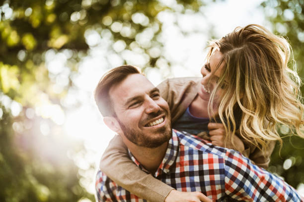 istock Young cheerful couple having fun while piggybacking in springtime. 1188183601