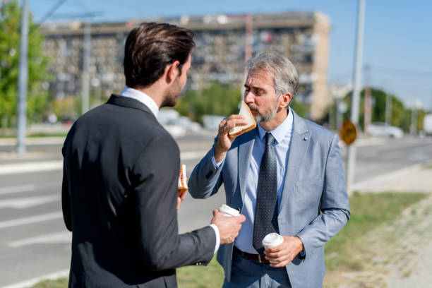istock Two businessmen eating lunch on the go 1188195530