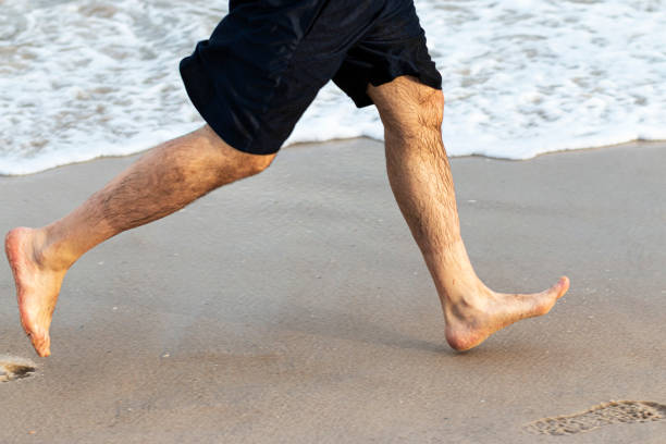 istock Barefoot runner on the beach next to the water 1188196425
