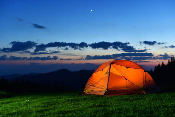 istock orange tourist tent stand on grass 1188200371