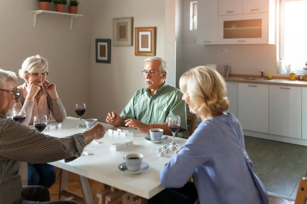istock Two Senior Couples Are Playing Dominoes 1188201858