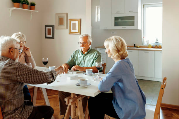 istock Two Senior Couples Are Playing Dominoes 1188201886