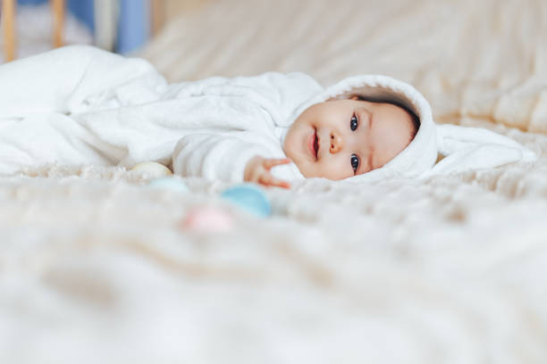 istock baby in rabbit white costume play with eggs at home 1188204647