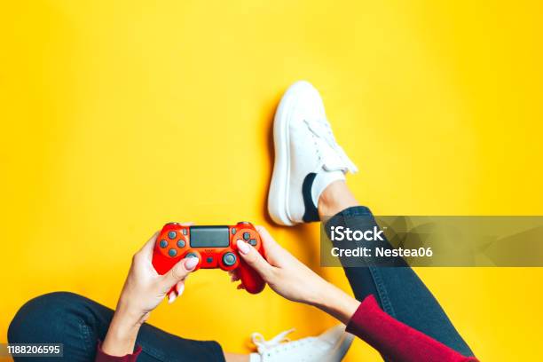 Young Woman Playing With Two Gamepads On Yellow Stock Photo - Download Image Now - Video Game, Gambling, Gamer