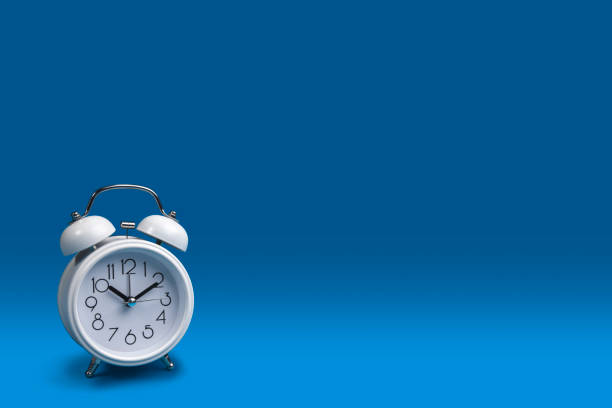 istock a white alarm clock with a dark blue background. 1188211528