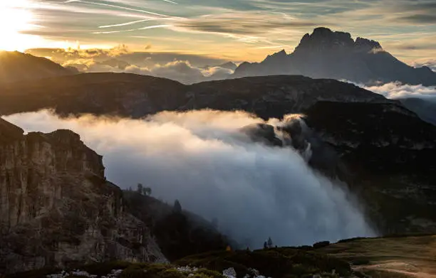 Mountain landscape with fog, late in the evening of the picturesque Dolomites at Tre Cime hiking path area in South Tyrol in Italy.